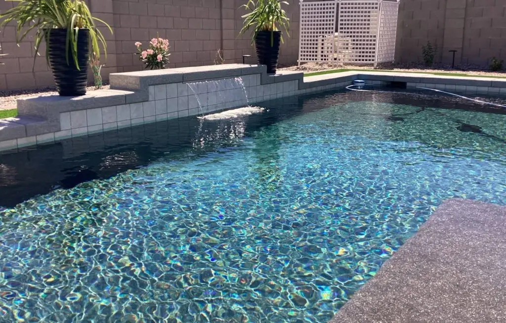 Modern pool with stone water wall and clean geometric design.