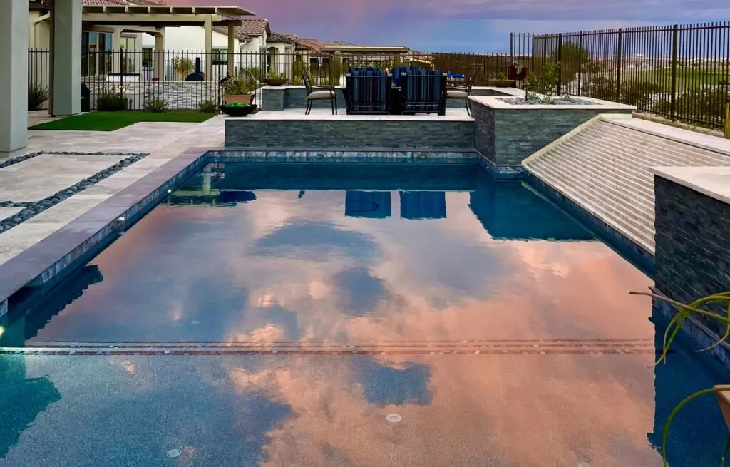 Modern pool reflecting sunset colors in the water.